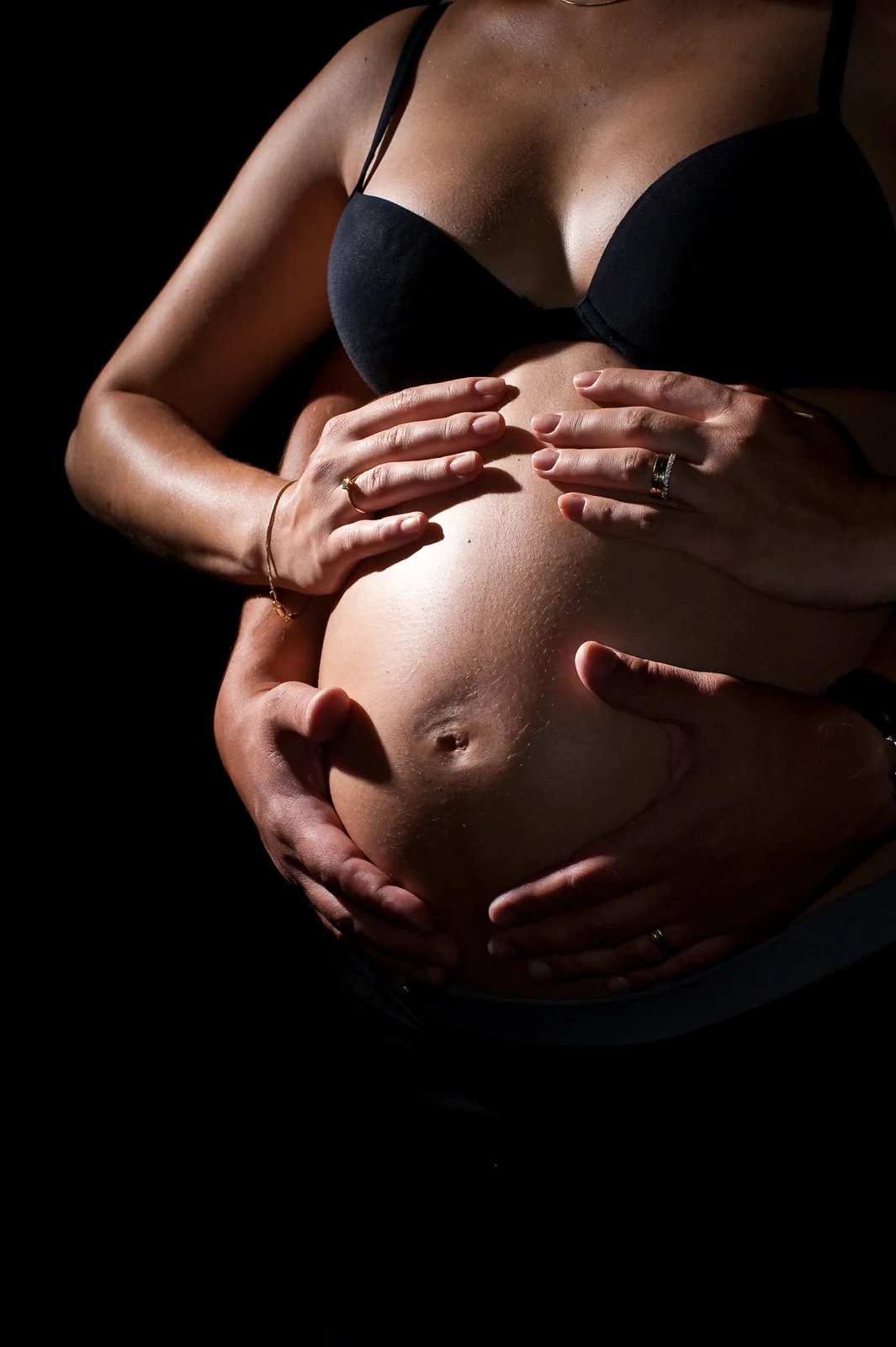Des mains posées sur un ventre de grossesse